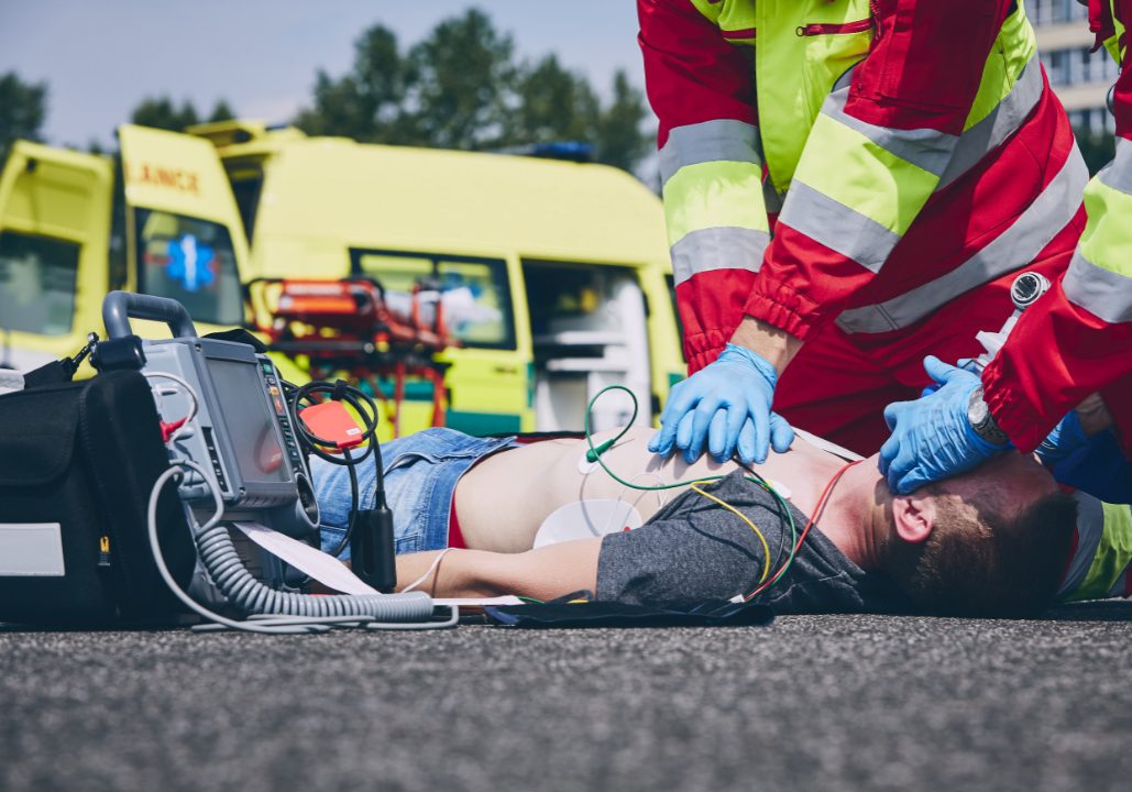 Cardiopulmonary resuscitation. Rescue team (doctor and a paramedic) resuscitating the man on the road.